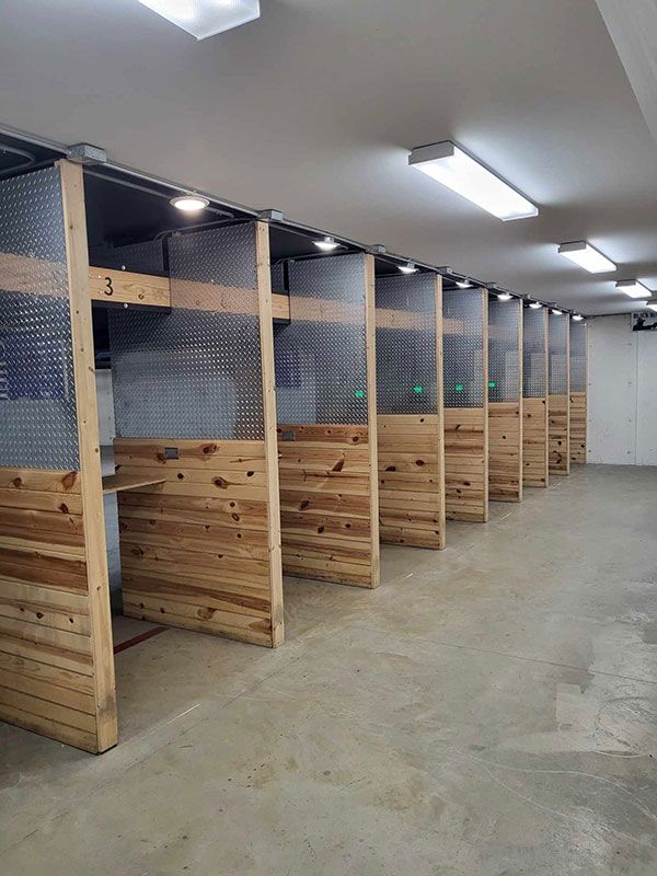 A row of wooden cubicles in a room with a concrete floor.