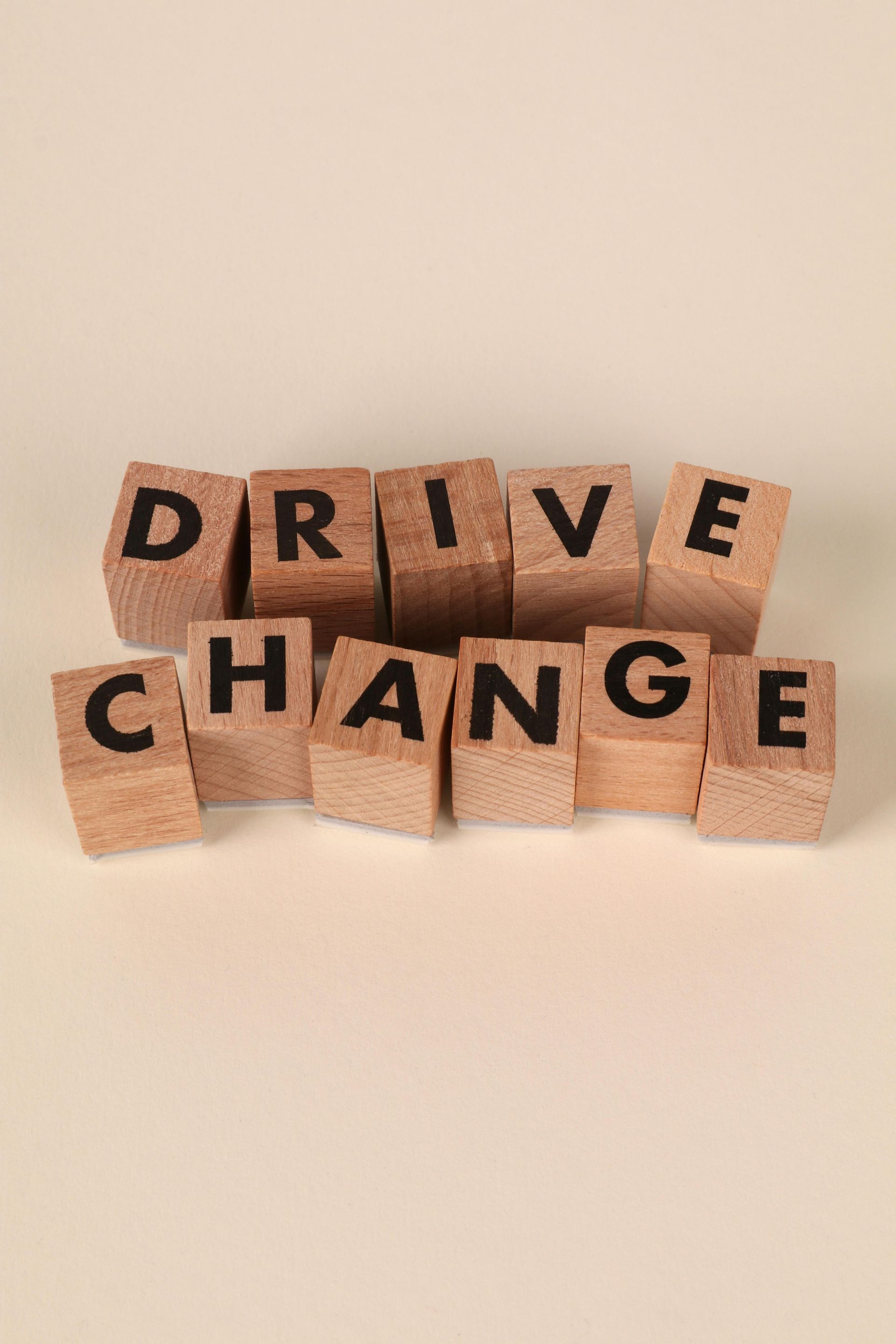 Wooden blocks spelling the word DRIVE on a beige background.