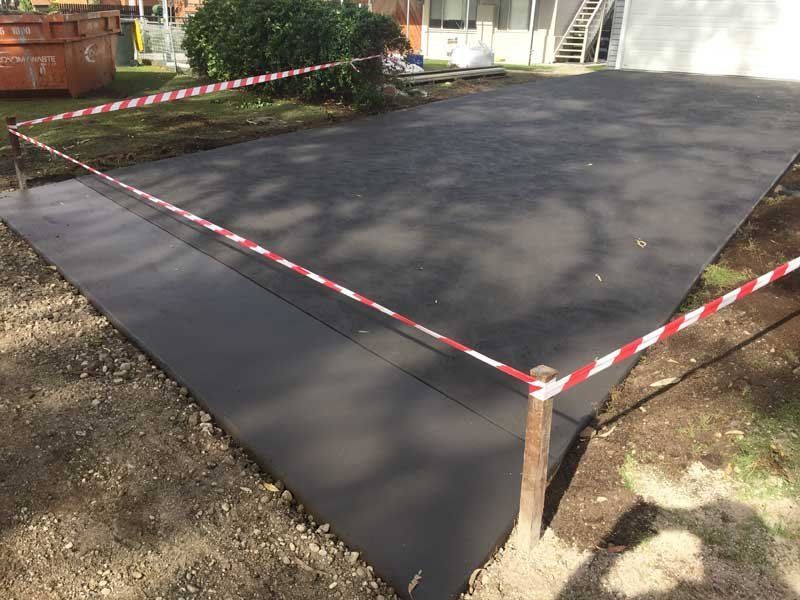 caution tape by wet concrete driveway