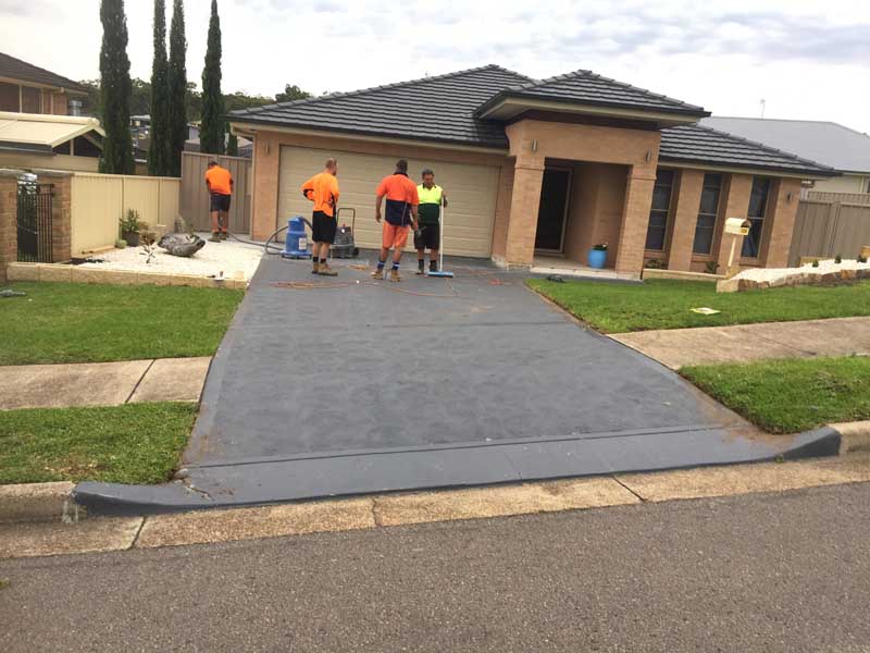 workers standing on new concrete driveway