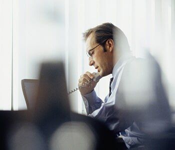 Businessman Using Phone In Office — Fort Worth Texas in Fort Worth, TX