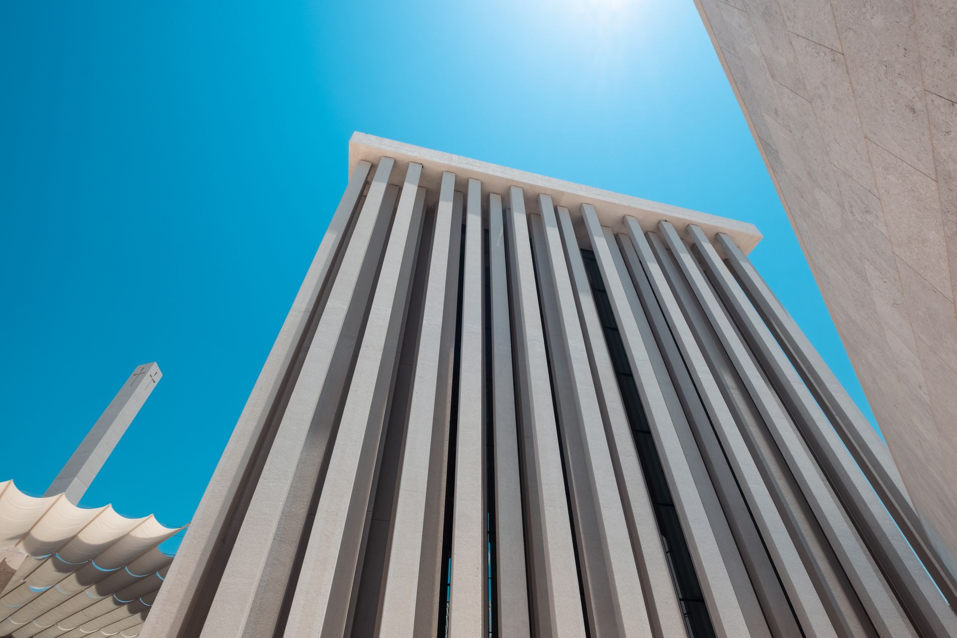 Building with Vertical Concrete Columns against blue sky.