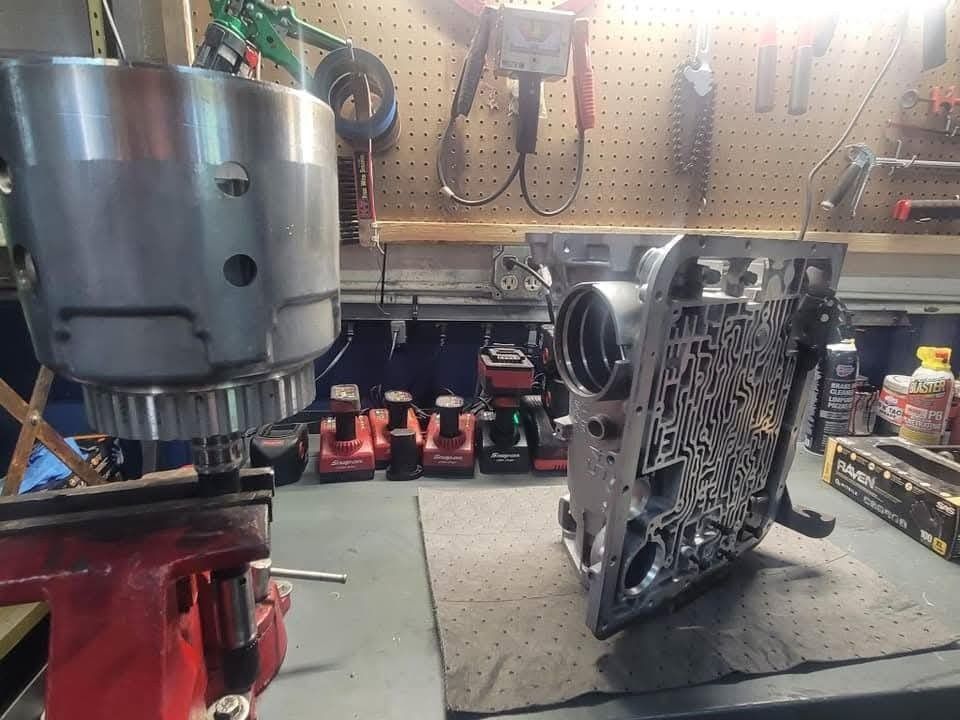 An automotive transmission assembly, partially disassembled on a workbench.