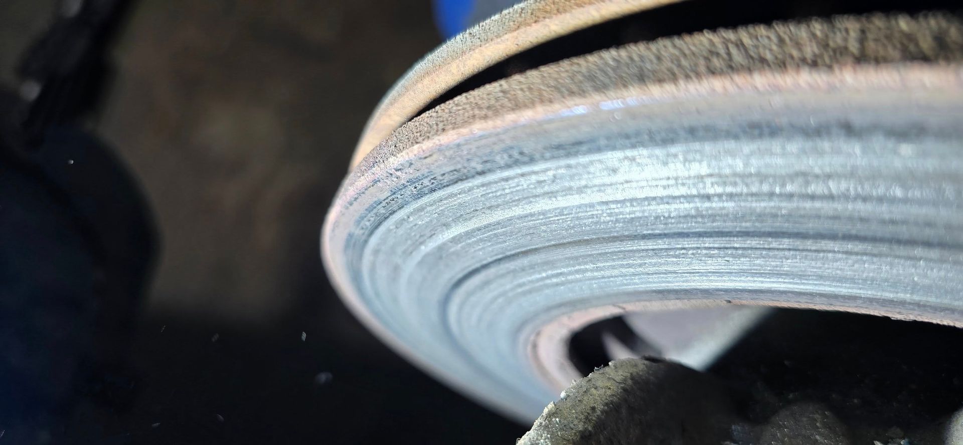 Close-up view of a worn brake rotor, showing multiple concentric rings and signs of wear.