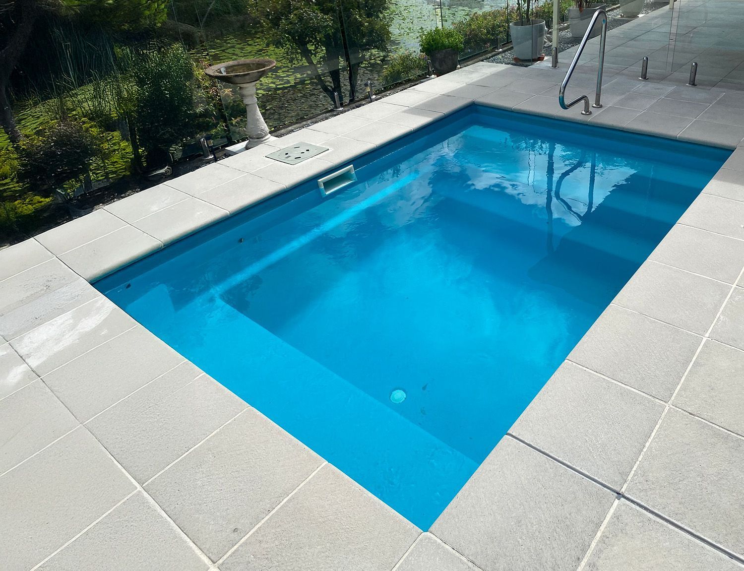 Backyard Swimming Pool With Steps, and Handrail