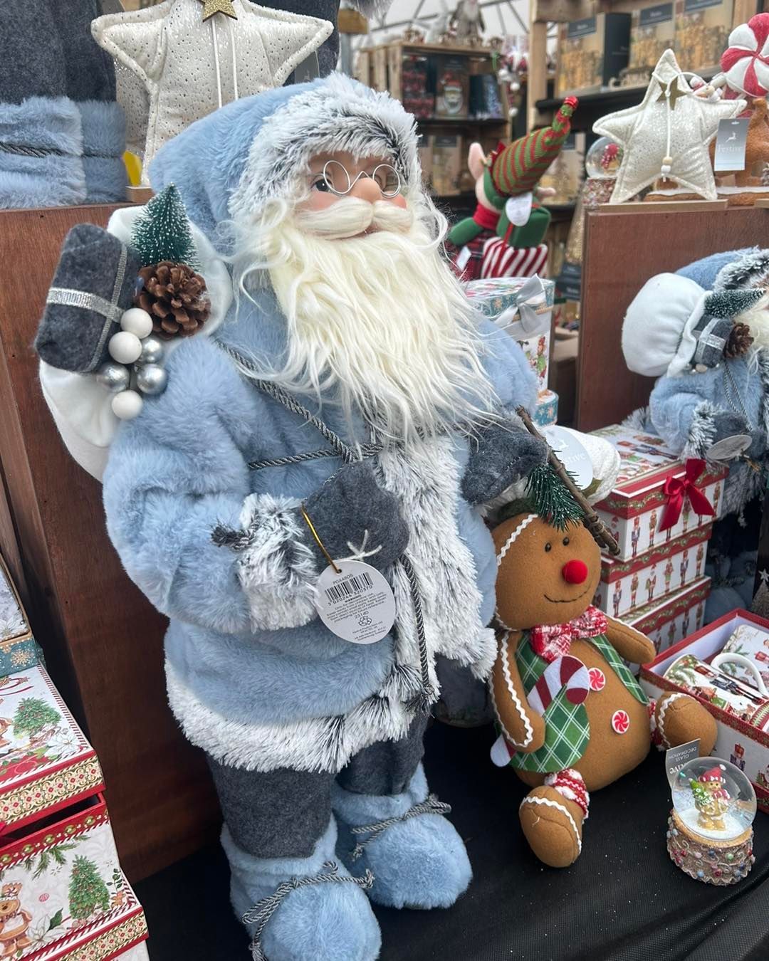 Blue Santa Claus figurine with gingerbread man, holiday setting.