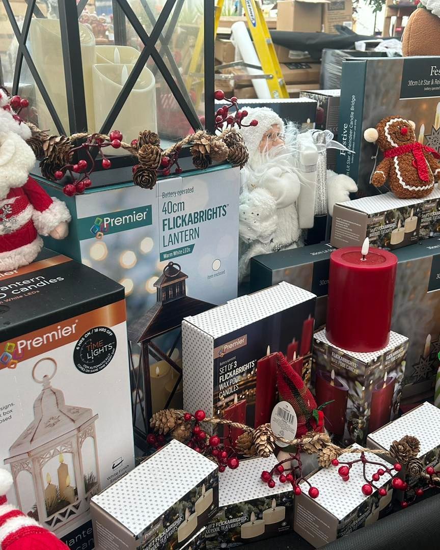 Christmas decorations on display: lanterns, lights, Santas, and candles in a store.