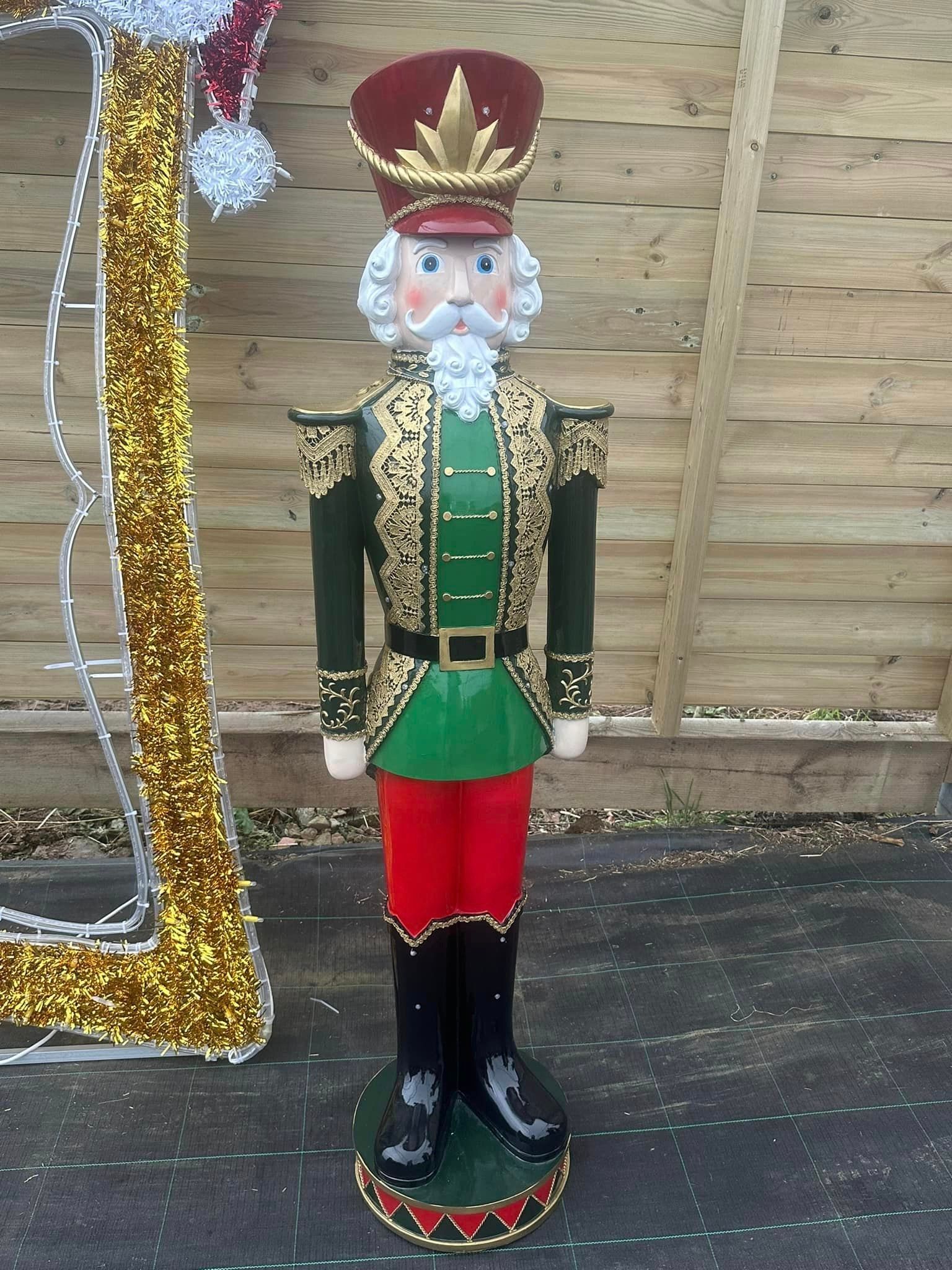 Large Christmas nutcracker figure in red, green, and gold uniform.