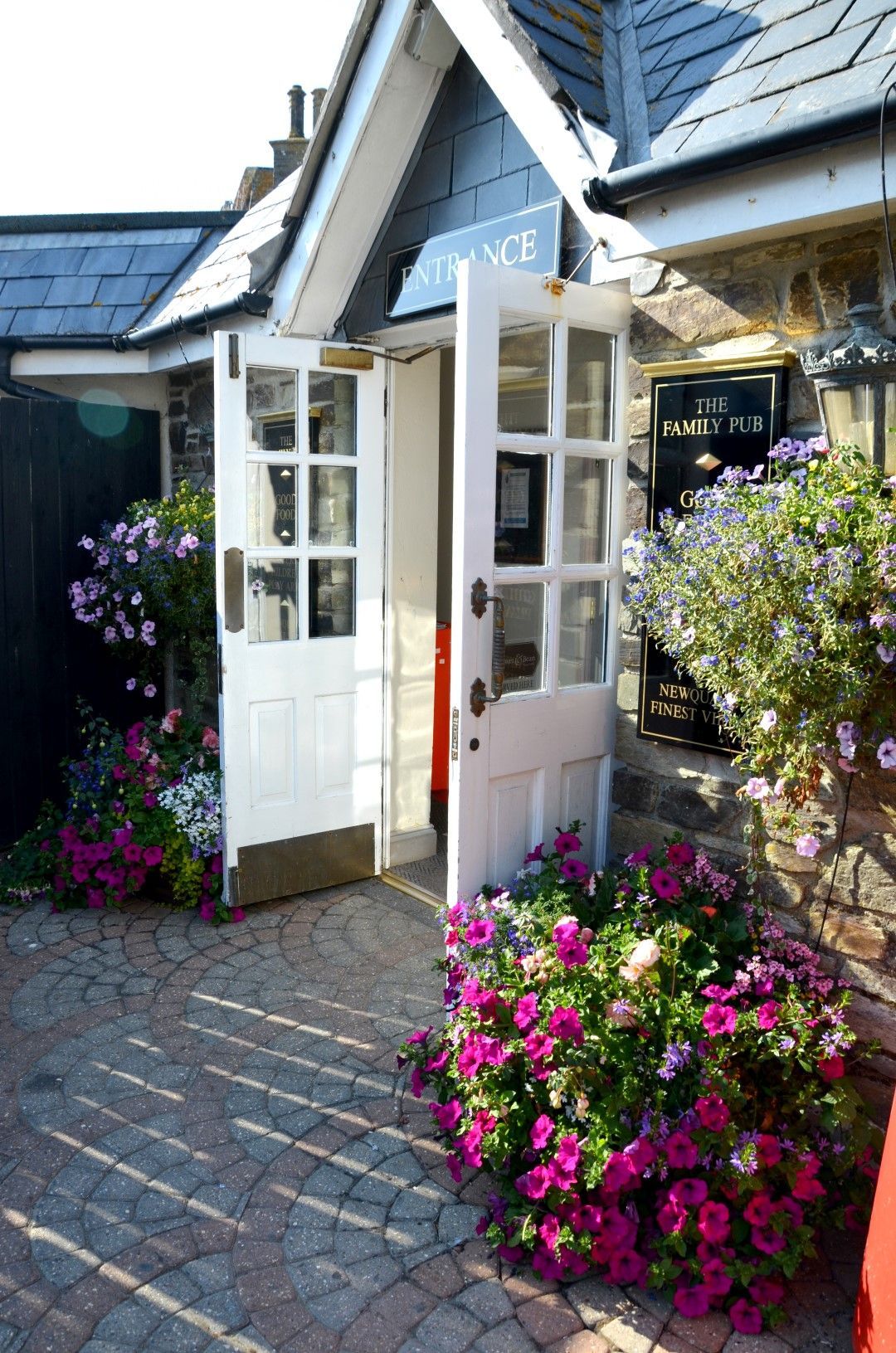 White open doorway with purple and pink flowers, inviting entrance.