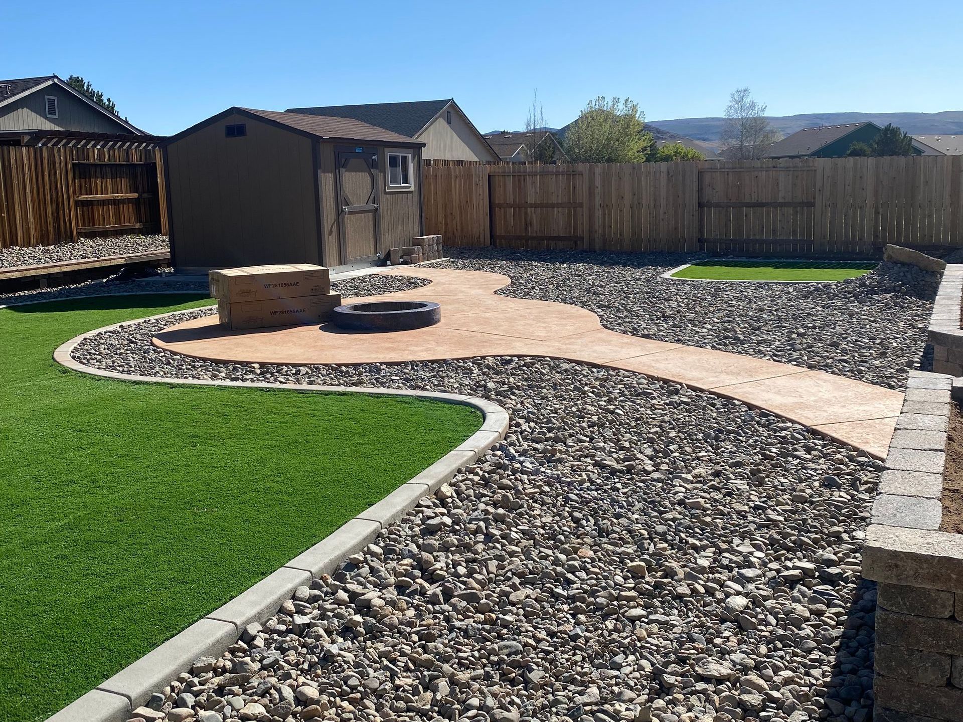 A backyard with a shed and a walkway leading to it.