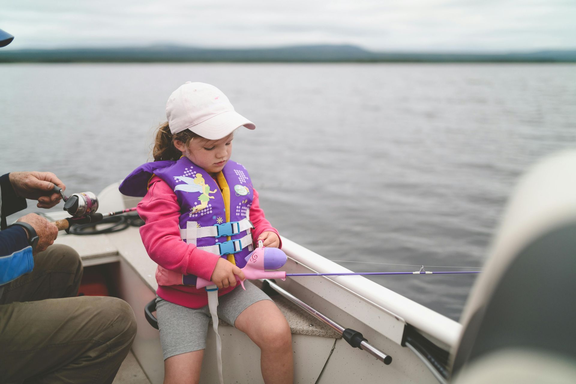 A row of solar panels in a field with a cloudy sky in the background.