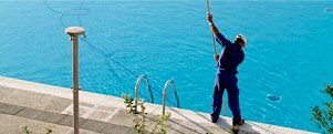Swimming Pool Equipment & Supplies Dealers — Man Cleaning the Pool  in Gainesville, FL