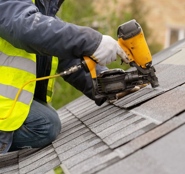 Professional Worker Installing New Shingles Roof