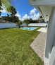 There is a swimming pool in the backyard of a house.