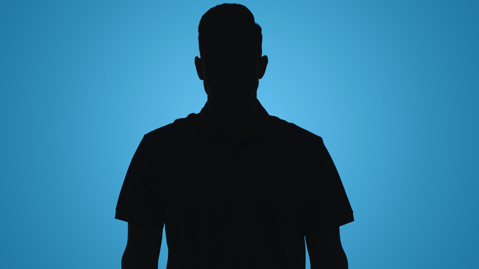 Silhouette of a person in a collared shirt against a blue background.