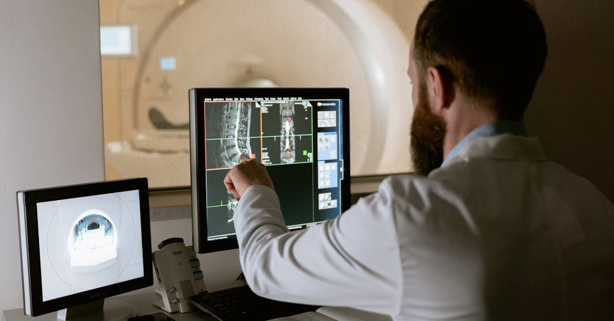 A man in a lab coat is looking at a computer screen.