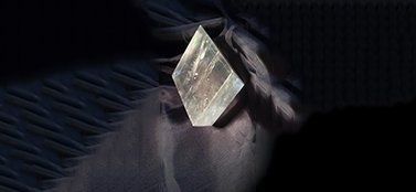 Un primo piano di un cristallo su una superficie nera.