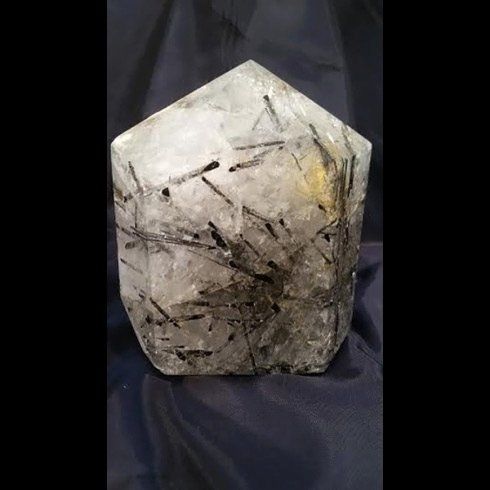 Un grande cristallo appoggiato su un panno blu su un tavolo.