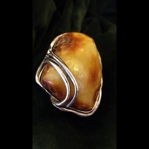 Un primo piano di un anello con una grande pietra al suo interno