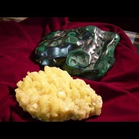 Una roccia verde e una roccia gialla sono su un panno rosso