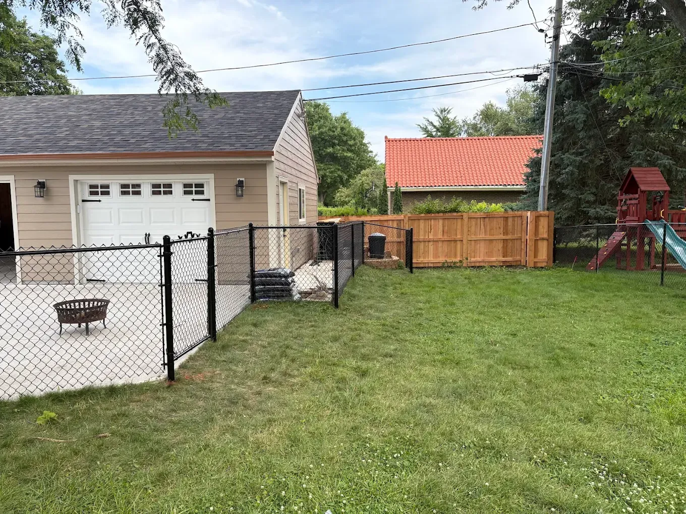 Backyard with lawn, fences, garage, and play structure.
