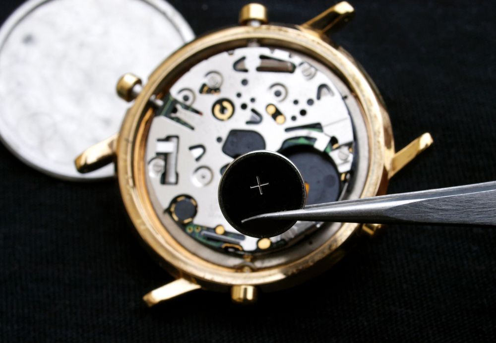 A Close Up of the Inside of a Watch With a Battery Being Removed — K. Smith & Son Jewellers In Caloundra, QLD