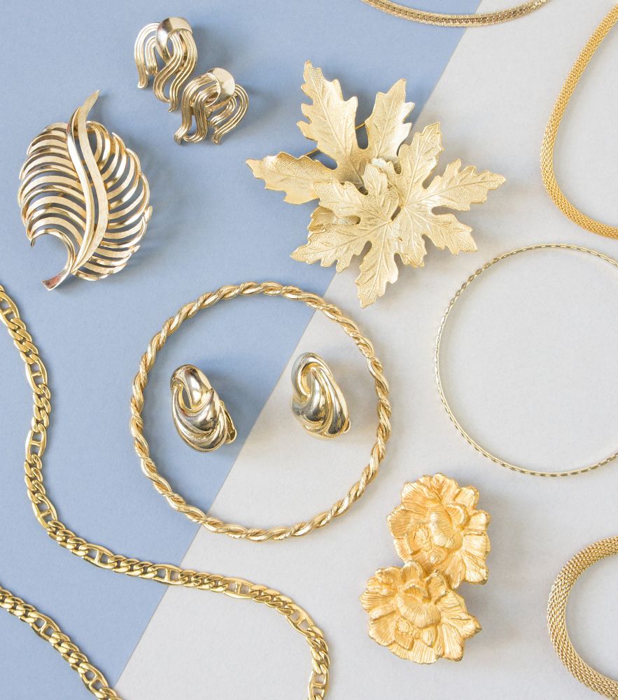 A Variety of Gold Jewelry on a Blue and White Surface — K. Smith & Son Jewellers In Noosa, QLD