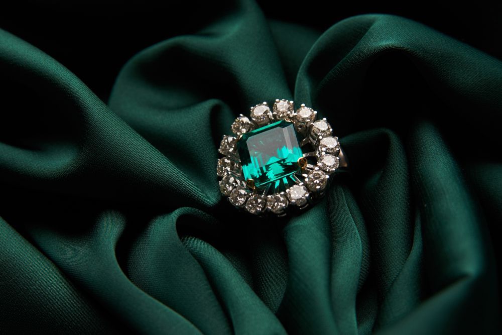 A Ring With an Emerald and Diamonds on a Green Cloth — K. Smith & Son Jewellers In Caloundra, QLD