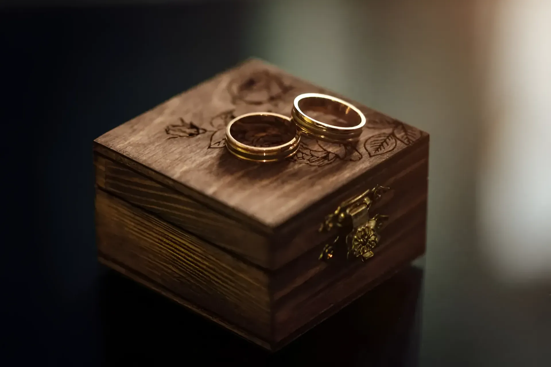 A Pair of Wedding Rings Are Sitting on Top of a Wooden Box — K. Smith & Son Jewellers In Caloundra, QLD