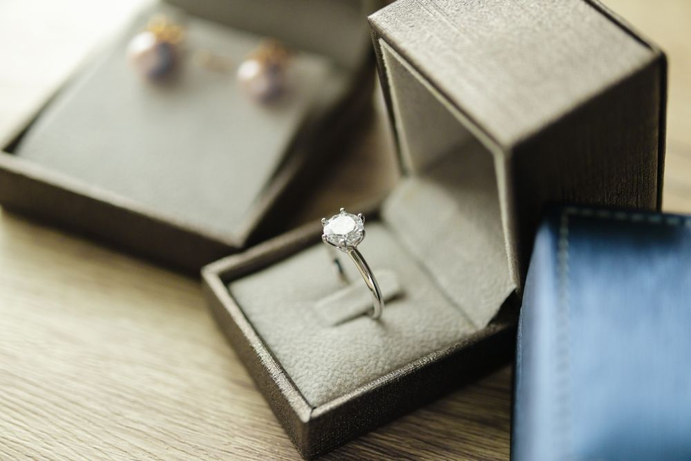 A Diamond Ring is in a Box Next to a Pair of Earrings — K. Smith & Son Jewellers In Caloundra, QLD