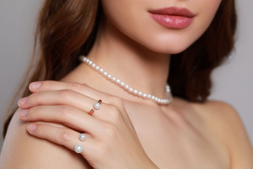 A Woman Wearing a Pearl Necklace and a Ring on Her Finger — K. Smith & Son Jewellers In Caloundra, QLD