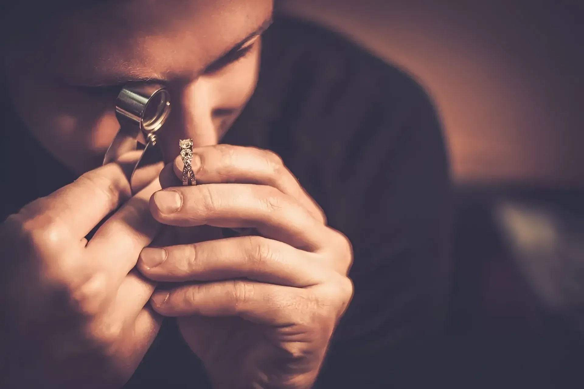 A Man is Looking at a Diamond Ring Through a Magnifying Glass — K. Smith & Son Jewellers In Caloundra, QLD