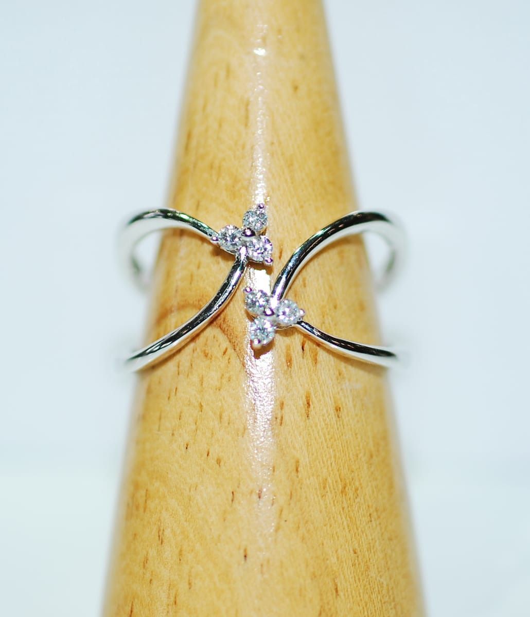 Silver Ring with Two Crossing Bands and Three Small Diamond-Like Accents, Displayed on A Wooden Ring Holder — K. Smith & Son Jewellers In Caloundra, QLD