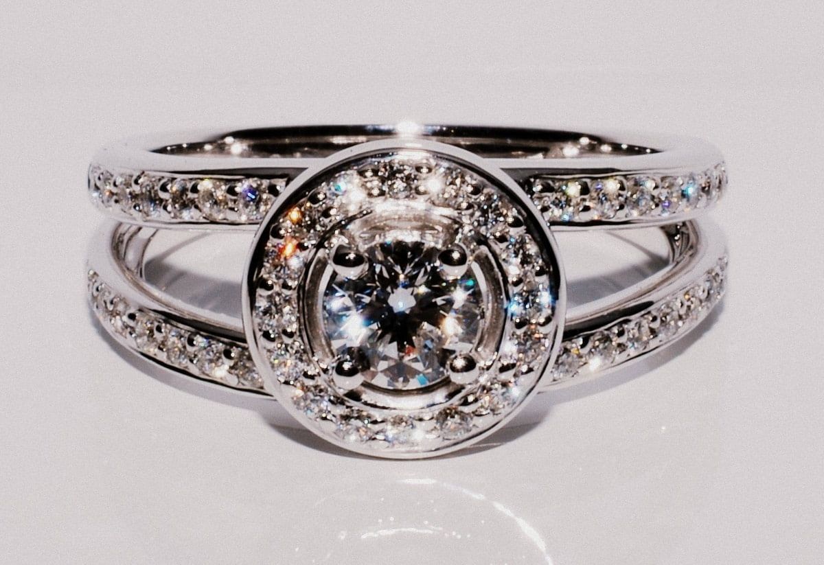 Silver Engagement Ring with A Large Central Diamond Surrounded by Smaller Stones, and A Split Band Lined with More Diamonds — K. Smith & Son Jewellers In Caloundra, QLD