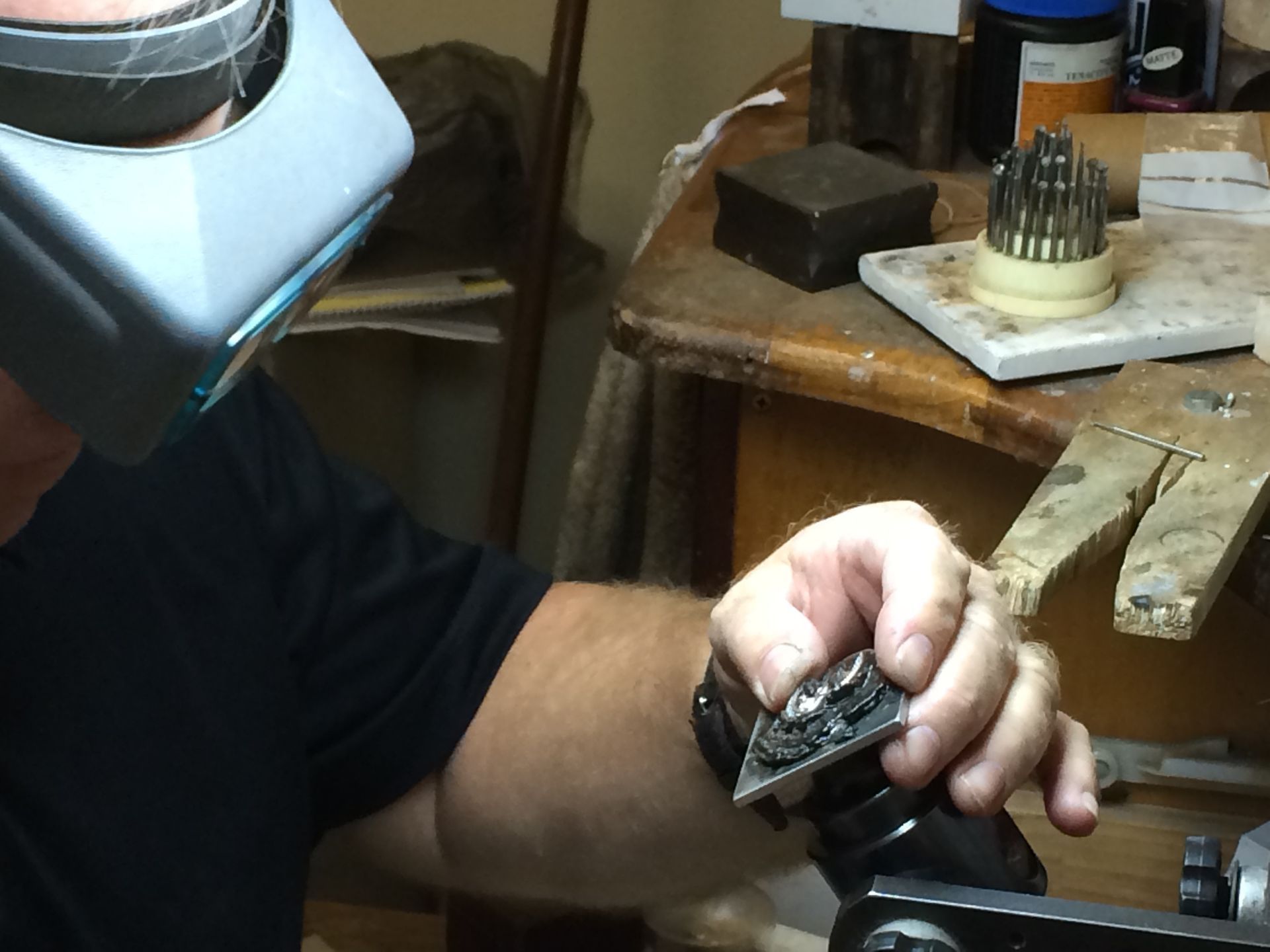 Person Holding a Ring with Tweezers, Likely Inspecting It. Close-Up Shot of Hands with Ring in Focus, Indoors — K. Smith & Son Jewellers In Caloundra, QLD