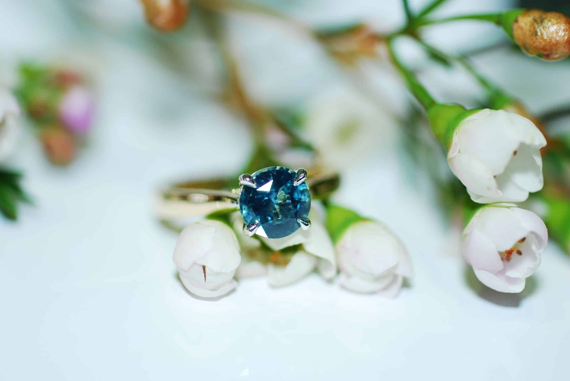 A Ring is Sitting on a Wooden Table Next to a Magnifying Glass — K. Smith & Son Jewellers In Caloundra, QLD