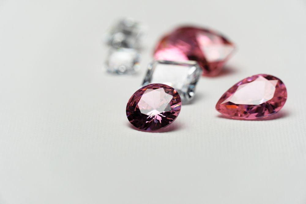 A Group of Pink and Purple Stones on a White Surface — K. Smith & Son Jewellers In Caloundra, QLD