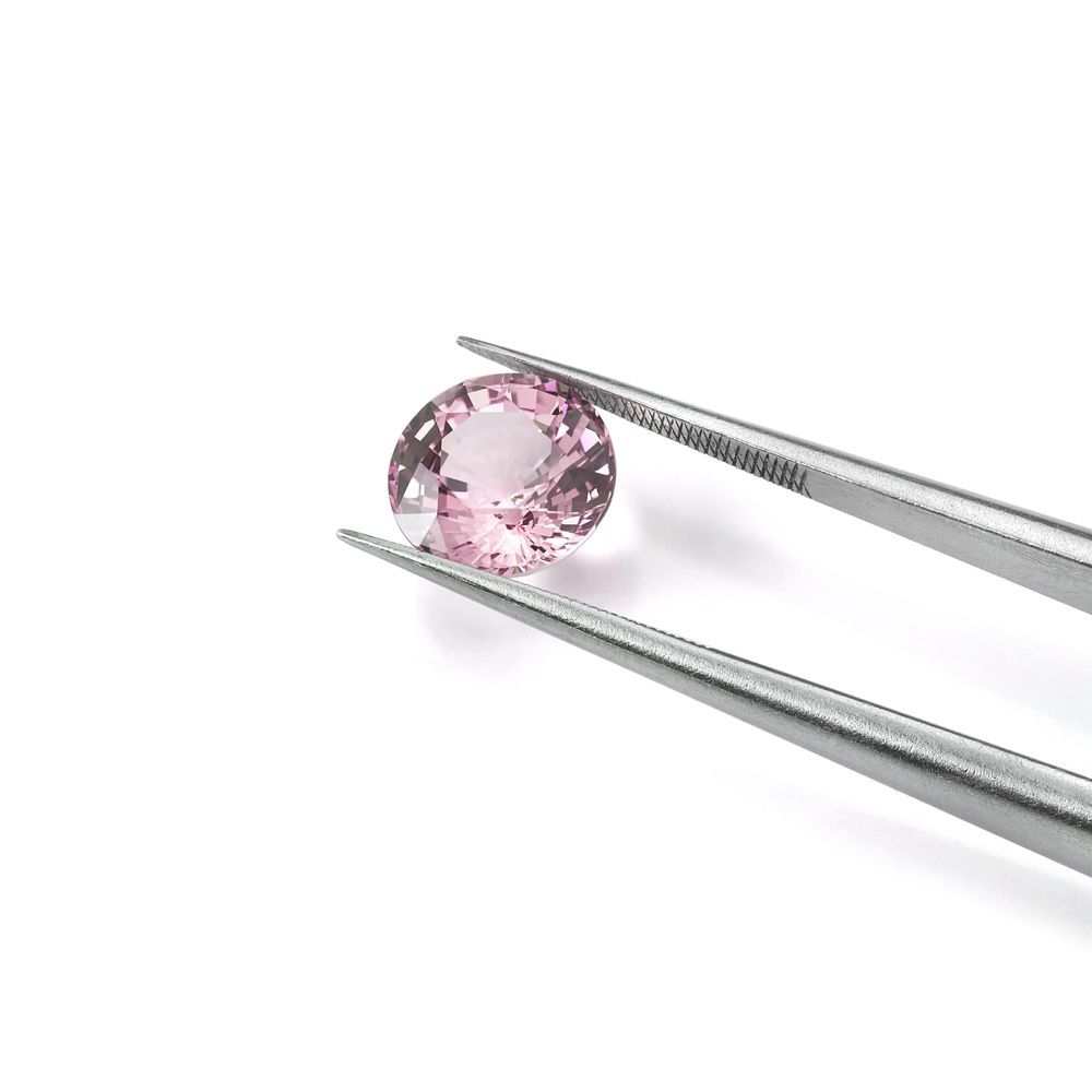A Pair of Tweezers Holding a Pink Stone on a White Surface — K. Smith & Son Jewellers In Caloundra, QLD