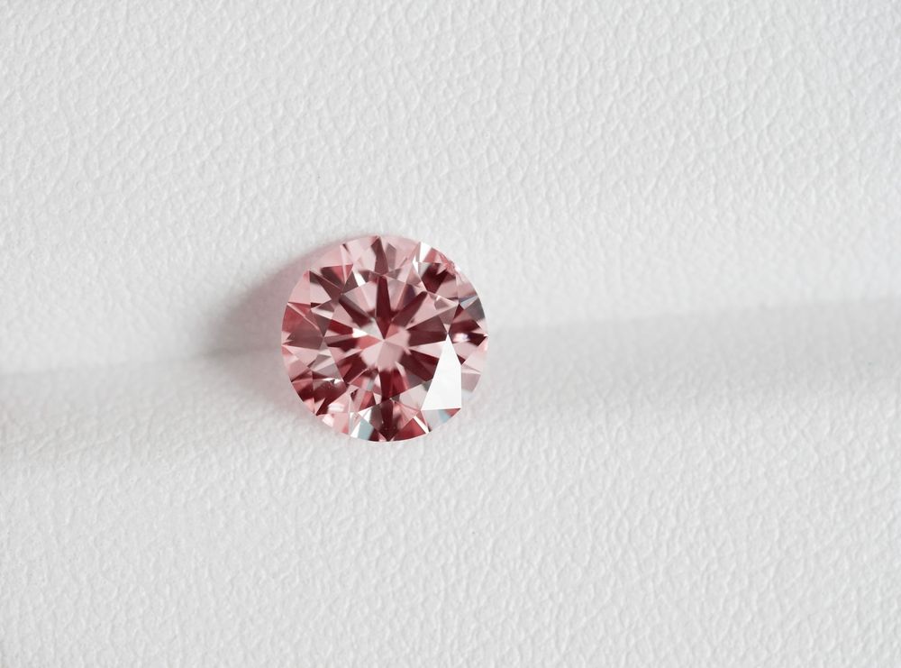 A Pink Diamond is Sitting on a White Surface — K. Smith & Son Jewellers In Caloundra, QLD