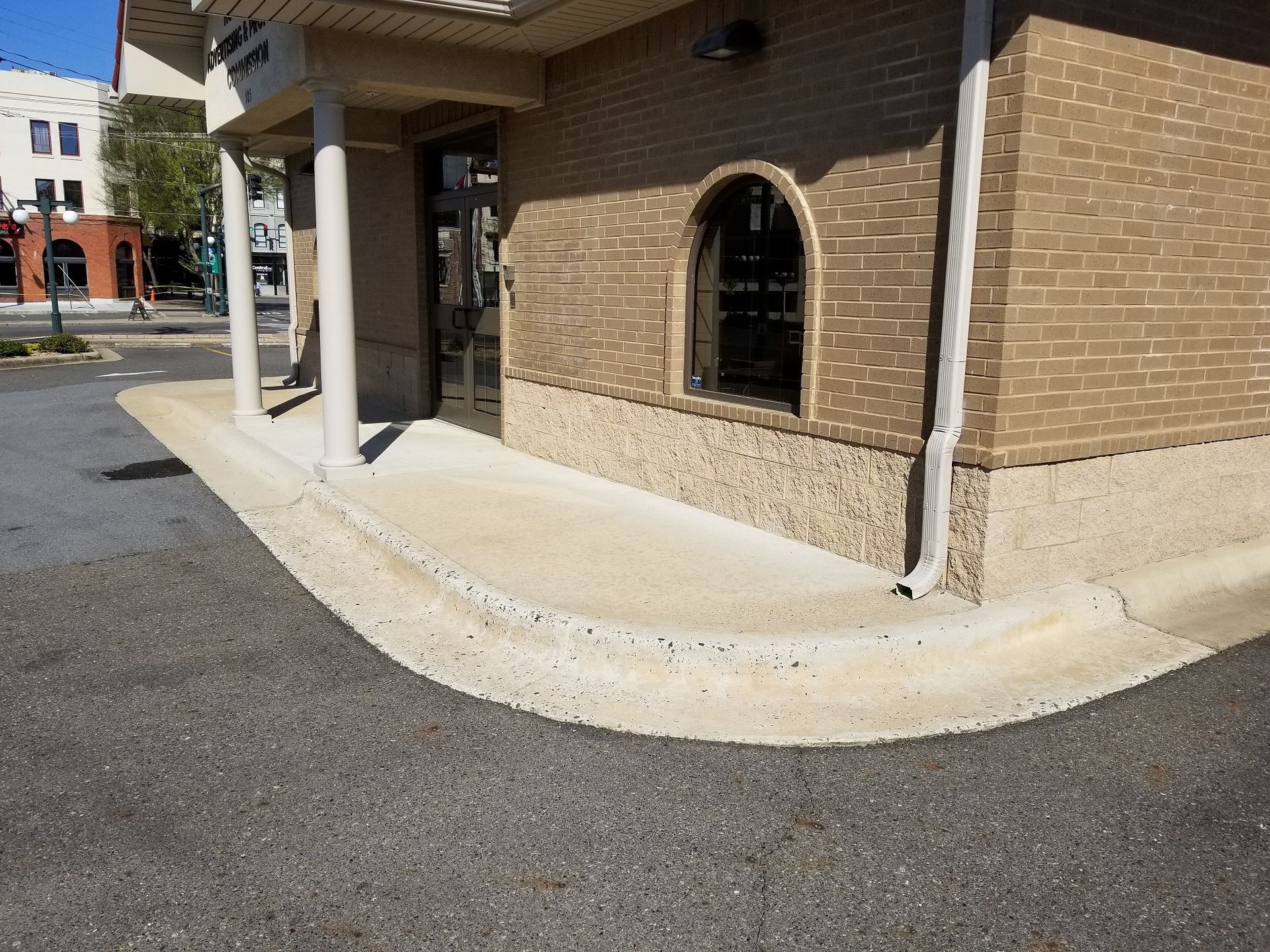 A corner of a brick building with a walkway leading to it