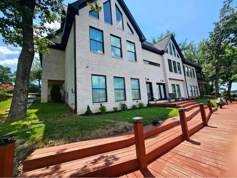 A large white house with a wooden deck in front of it