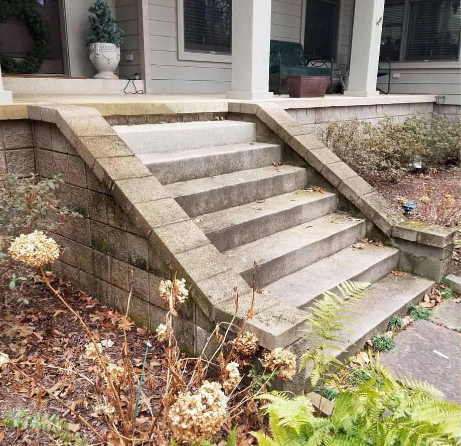 A set of stairs leading up to a porch of a house.