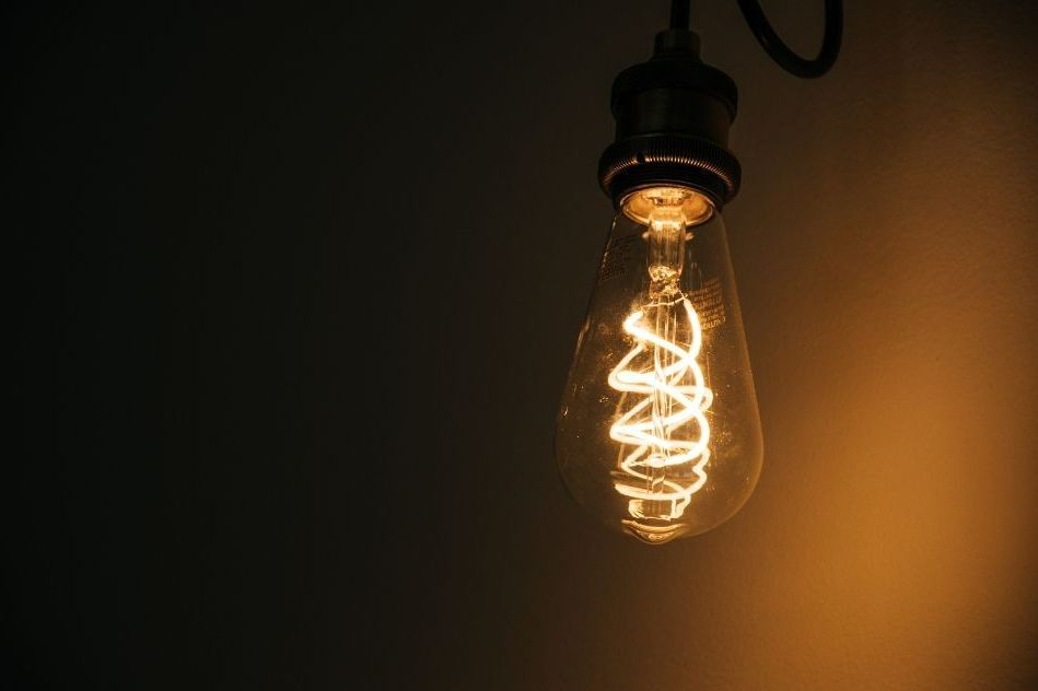 A close up of a light bulb hanging from a ceiling.