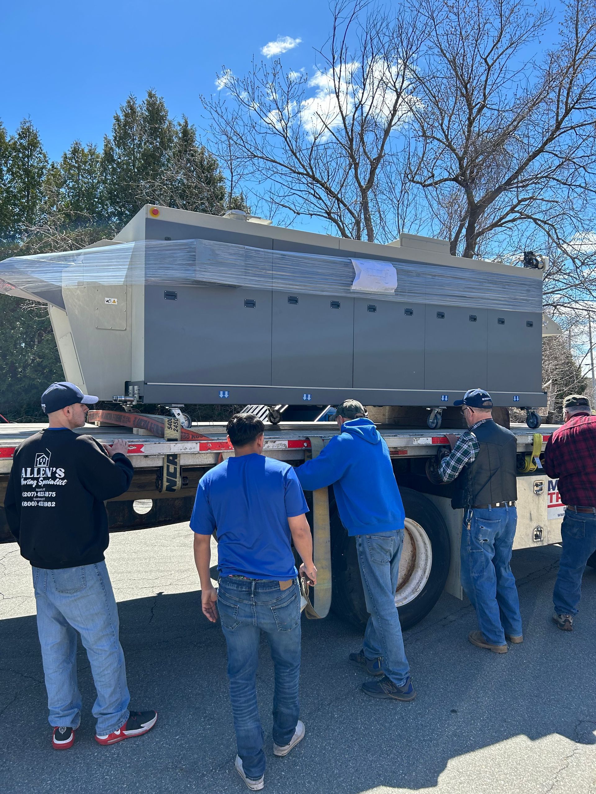 A group of men are standing in front of a semi truck.