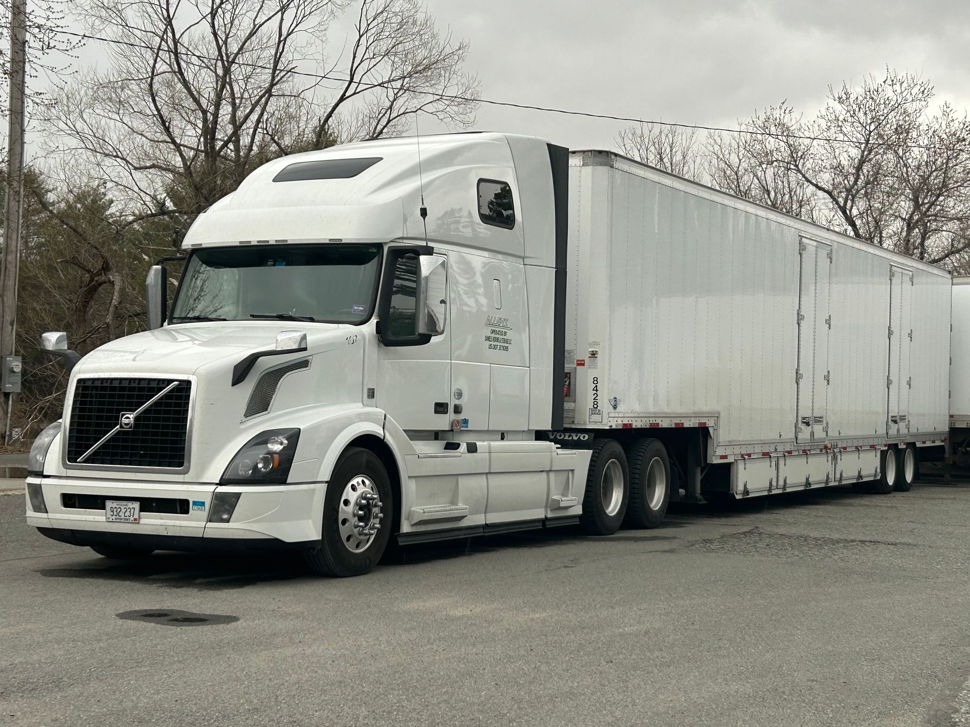 A white semi truck is parked on the side of the road.