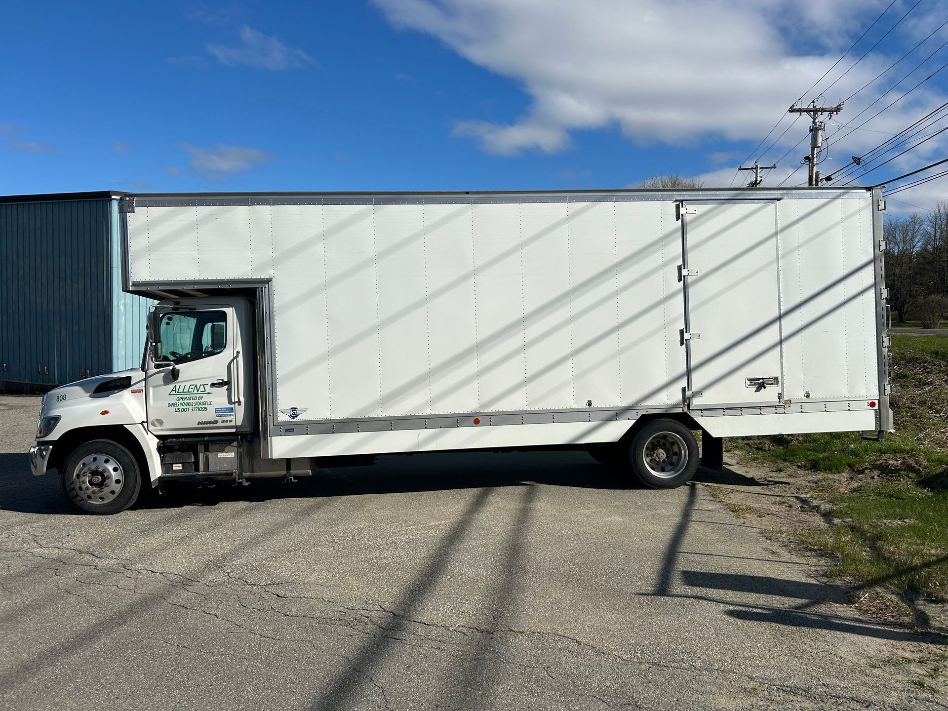 A white moving truck is parked on the side of the road.