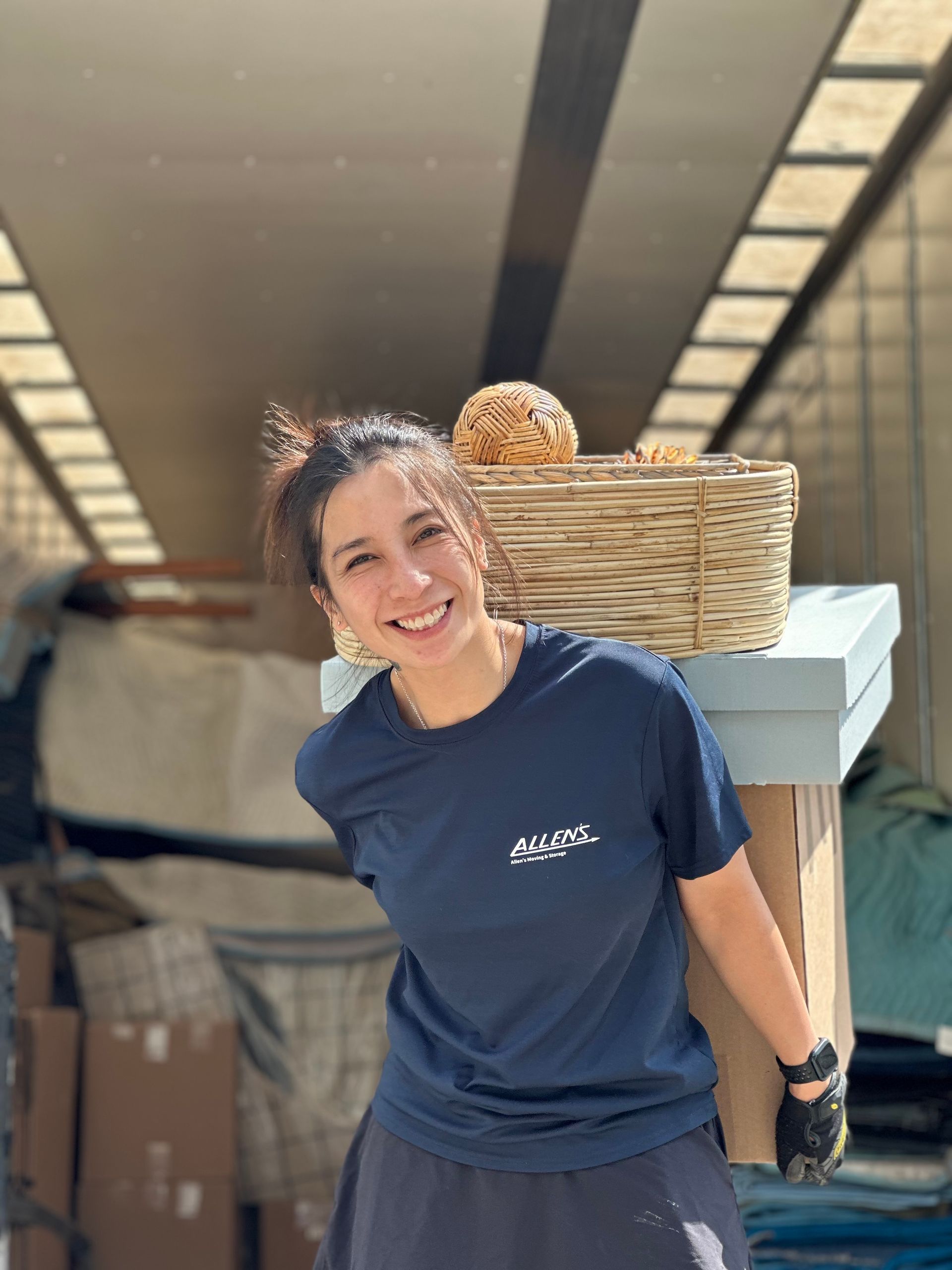 A woman is carrying a basket of bread on her back.