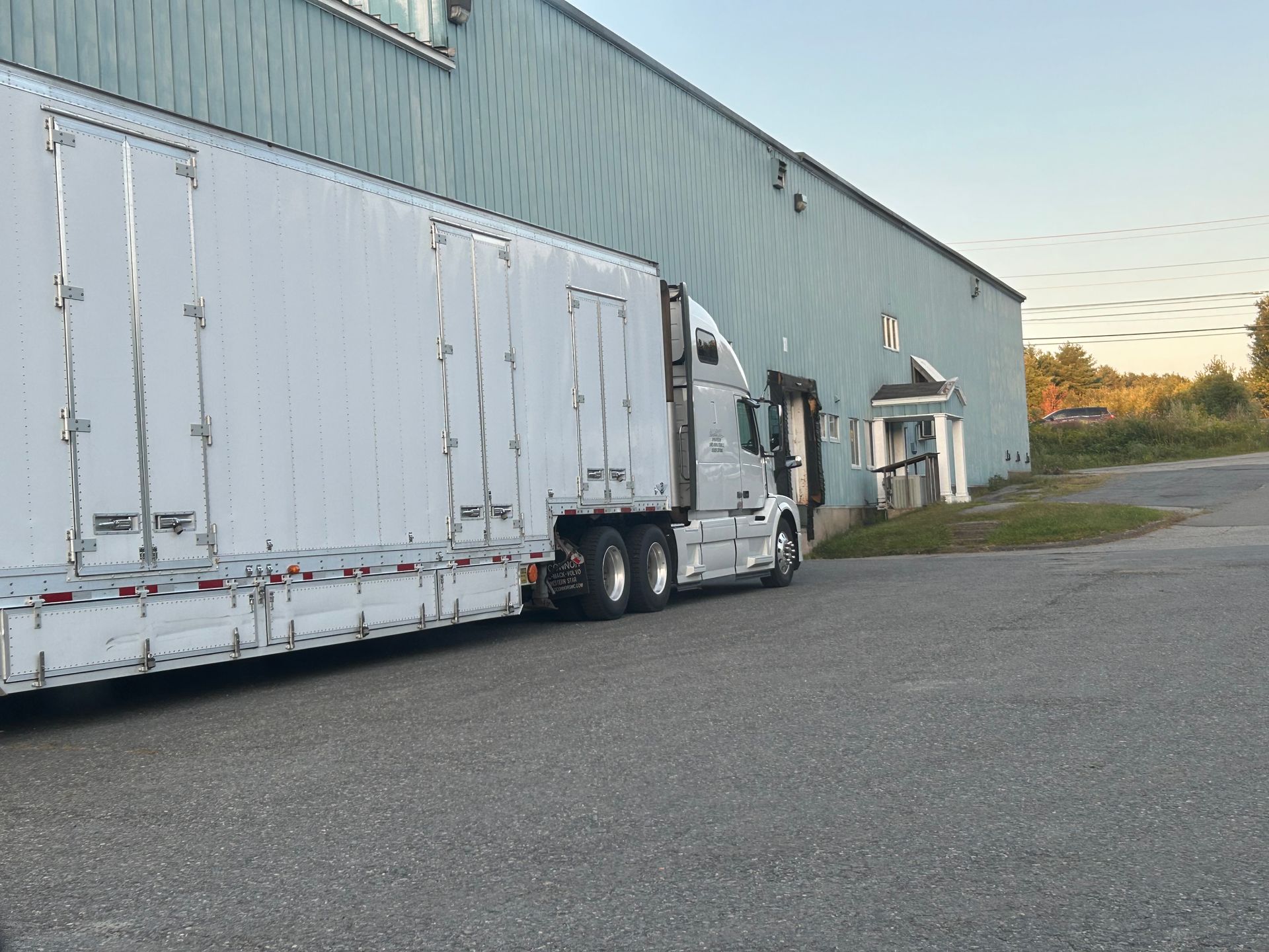 A white semi truck is parked in front of a building.