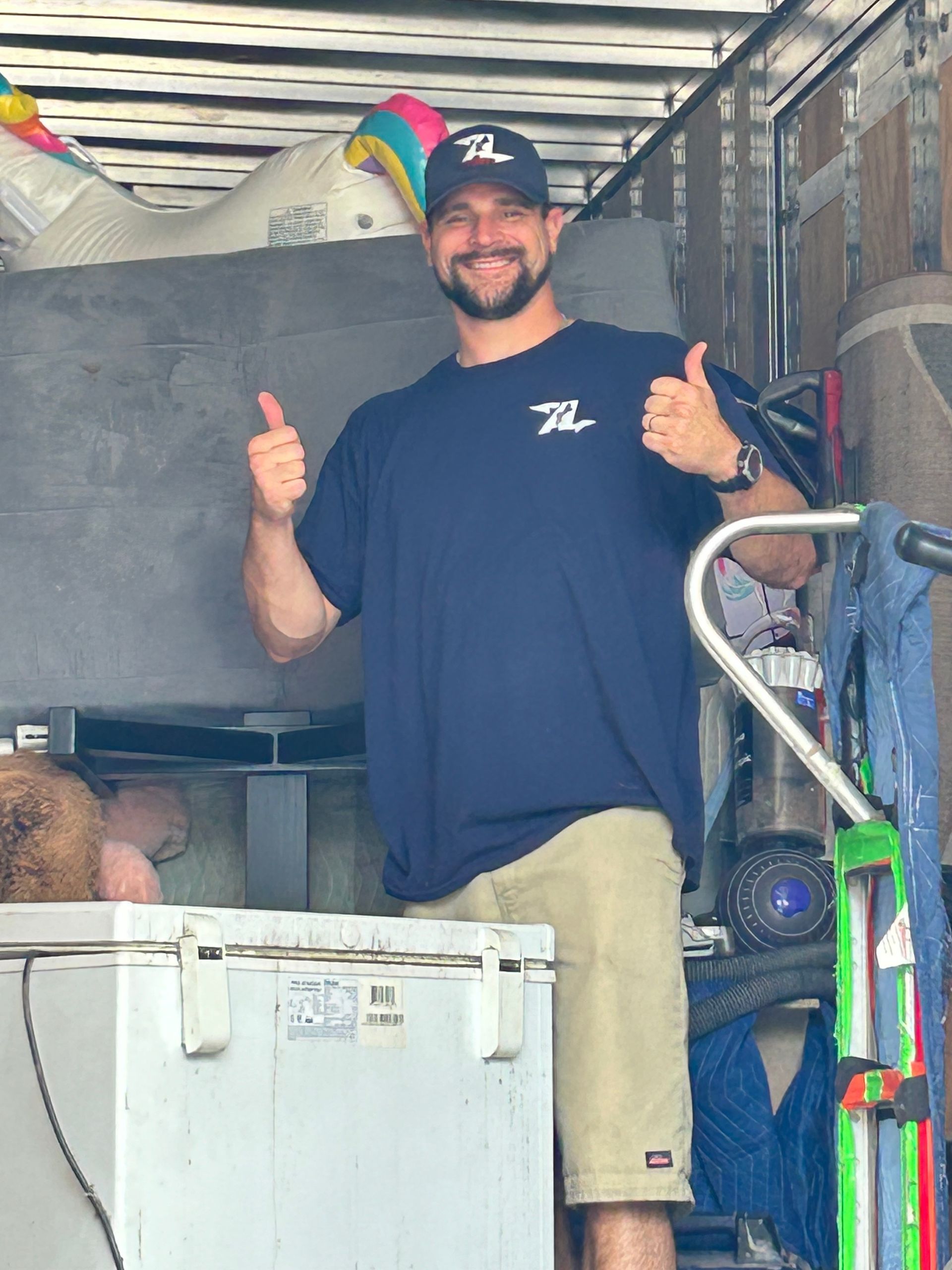 A man in a blue shirt is giving a thumbs up