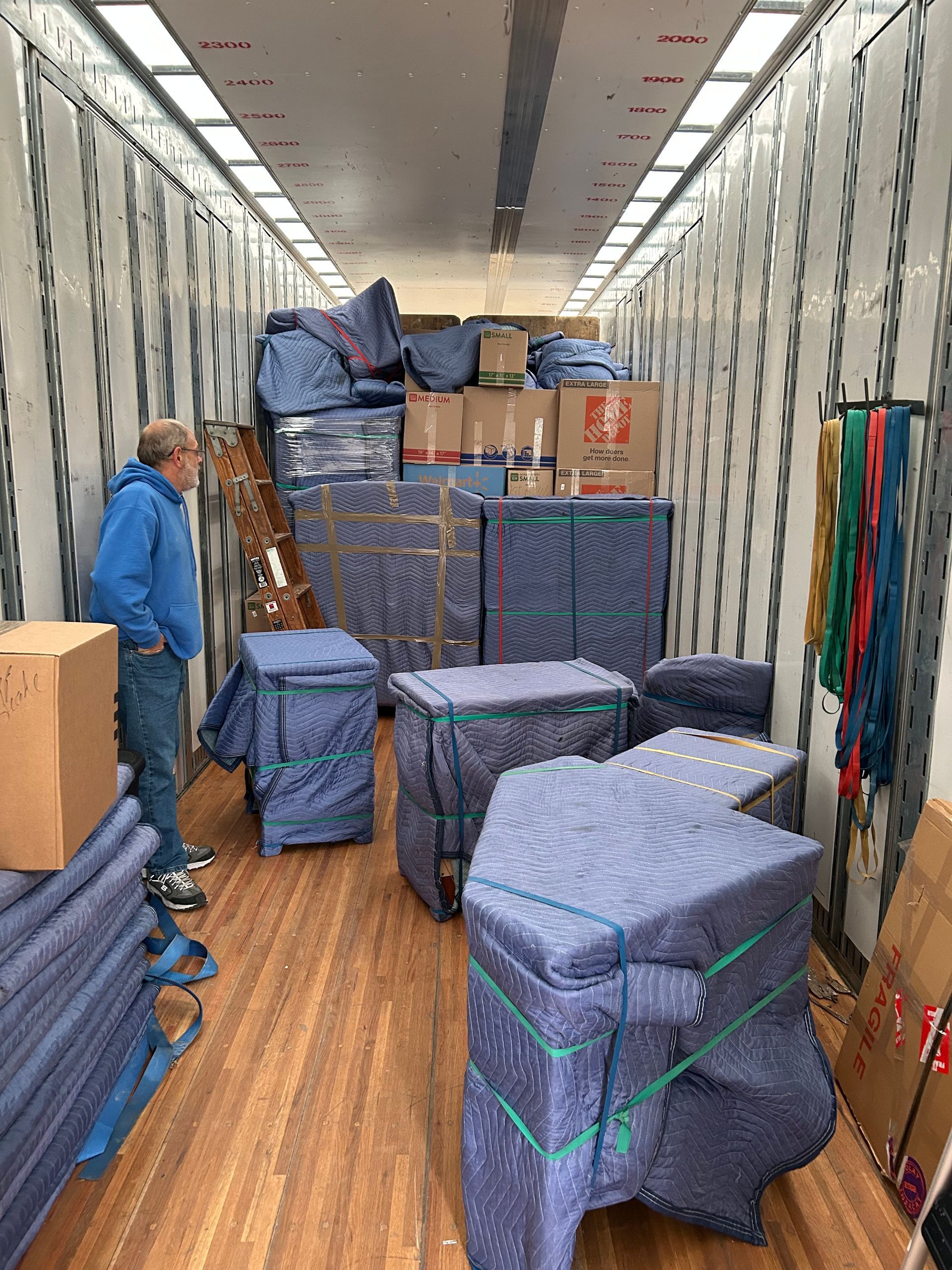 A man is standing in the back of a moving truck.